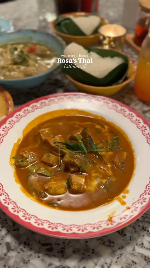 The video showcases a dinner at Rosa's Thai restaurant in Edinburgh. It features various dishes, including a passion fruit and jasmine bubble tea, a classic sharing platter with Thai fried chicken, spring rolls, pork skewers, calamari, prawn crackers, and dips; green chicken curry; panang chicken curry; sticky rice; and roti. The food is presented appetizingly, with a focus on color and texture.  No specific dietary information is provided.