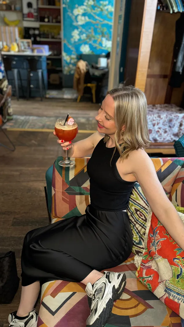 The video showcases a bottomless brunch at the Little Yellow Door in London.  It features various cocktails (Aperol Spritz, pink cocktails, champagne), a pretzel bun sandwich with a fried egg and bacon, and stacks of pancakes. The food is presented on colorful plates and the drinks in elegant glasses. The setting is a vibrant, eclectic cafe/bar with colorful furniture and decor.  No dietary information is explicitly provided.