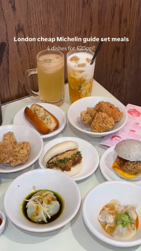 A fast-paced video montage showcasing a set meal at Bao, a Taiwanese restaurant in London. The video displays a variety of dishes including a beef rice bowl with an egg yolk, chicken rice, noodle soup, dumplings, fried chicken, and several types of bao buns. A person is shown eating the food. The video concludes with shots of the restaurant's interior and exterior signage. A persistent text overlay highlights the deal: 'London cheap Michelin guide set meals, 4 dishes for £25pp!!'.
