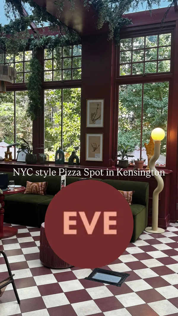 A video showcasing a lunch experience at Eve restaurant in Kensington. It features shots of the stylish, plant-filled interior and conservatory. The food highlighted includes two pizzas (a Hawaiian-style with jalapeños and a margherita) and a side salad, served on a tiered stand. There are close-ups of hot honey being drizzled on a pizza and a slice being pulled away. The video also shows drinks, including an Aperol Spritz and rosé wine, and a woman enjoying her meal.
