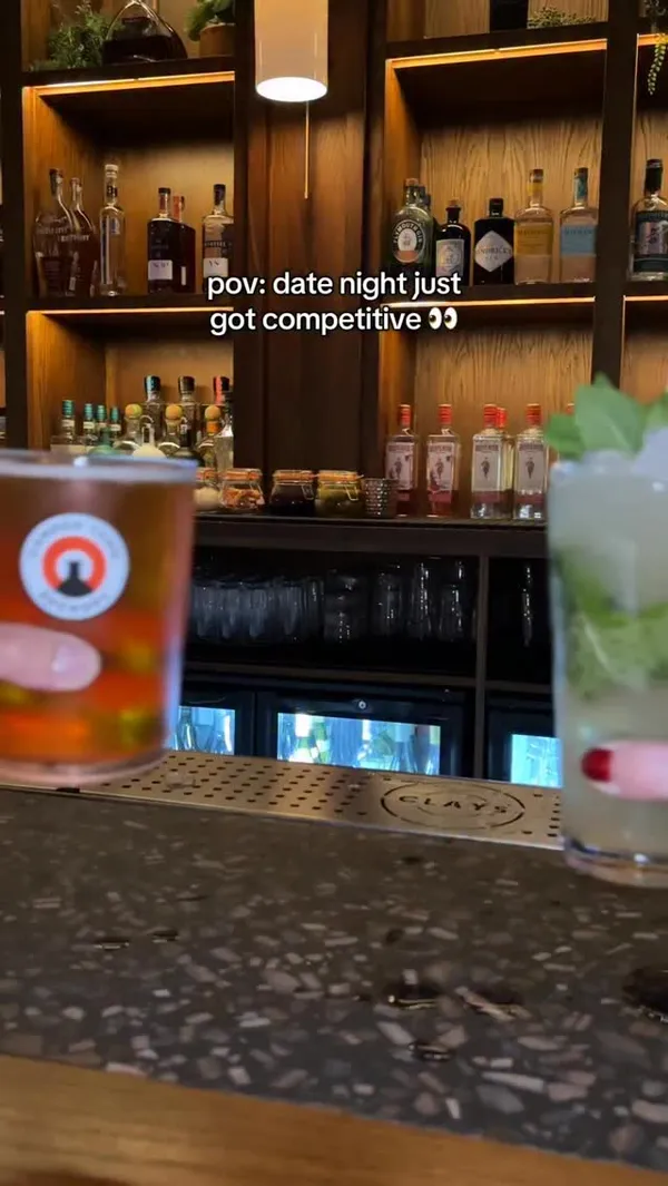 A short, energetic reel showcasing a date night at Clays in Soho. The video features the couple checking in, playing a digital clay pigeon shooting game, and enjoying cocktails and fries at the bar.