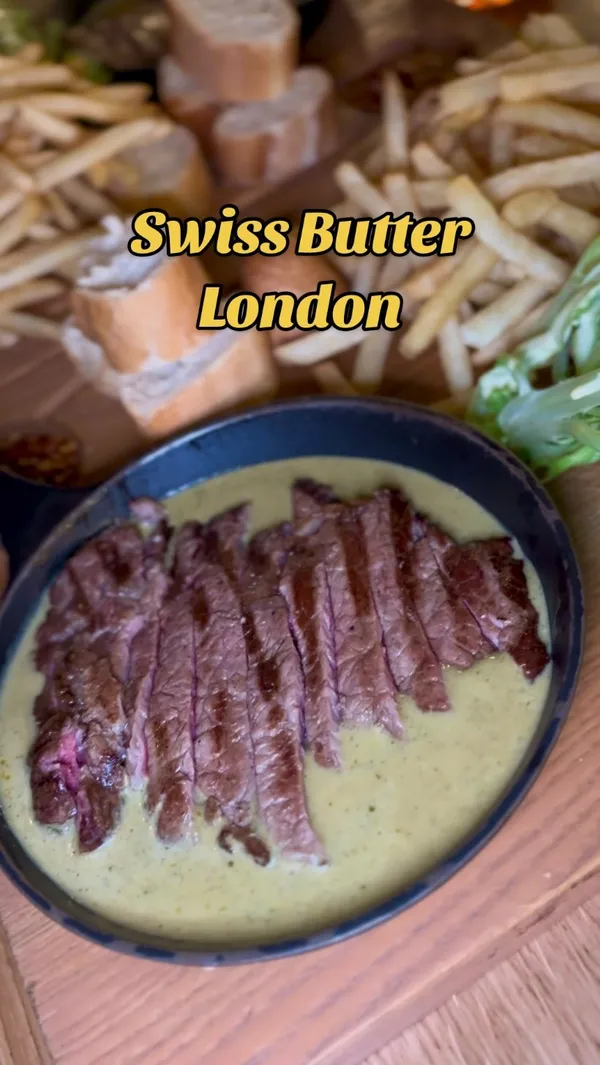 The video showcases a dining experience at Swiss Butter in London's Holborn. It features the restaurant's ambiance, exterior, and menu.  The main focus is on a ribeye steak dish with Swiss butter sauce, served with fries, baguette, and salad.  Two desserts, a chocolate molten and pain perdu, are also highlighted. The service by a staff member named Sharleen is praised.  No specific dietary information is provided.