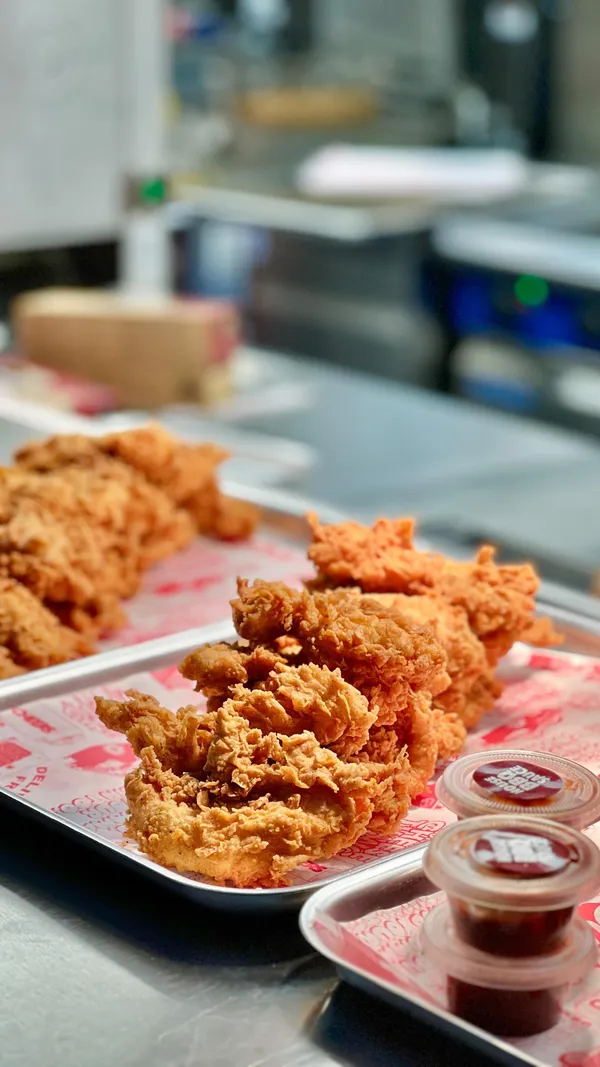 The video showcases the launch party of a new Butchies restaurant in London Bridge. It features various food items like fried chicken burgers, tenders, popcorn chicken, mac and cheese, and gelato.  The presentation focuses on close-up shots of the food, highlighting its texture and appearance. The video also mentions that the food is halal. The main focus is showcasing the food and the lively atmosphere of the launch party.