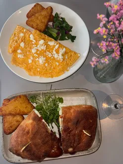 Brunch at Firedog Kitchen in Cockfosters featuring omelette and breakfast sandwich with Iberico bacon and crispy hash browns.