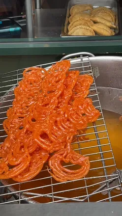 Delicious jalebi sweets served at a vibrant restaurant in London, perfect for food lovers and dessert enthusiasts.
