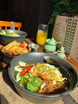 Colorful interior of Tuk Tuk Cardiff, showcasing Thai dishes, lush plants, and a vibrant atmosphere for casual dining.