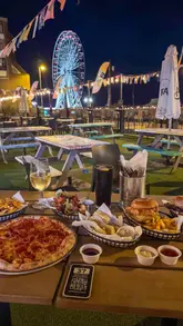 Stunning sunset view from Level 1 Rooftop Bar & Kitchen in Worthing, with seafront lights and vibrant atmosphere.