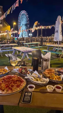 Stunning sunset view from Level 1 Rooftop Bar & Kitchen in Worthing, with seafront lights and vibrant atmosphere.