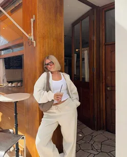 People enjoying a cozy outdoor gathering in autumn sunshine, surrounded by colorful fall leaves.