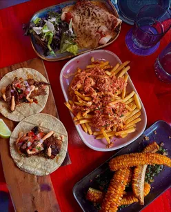 Delicious Mexican feast at Cabo in Edinburgh, featuring corn ribs, loaded fries, enchiladas, and steak tacos.