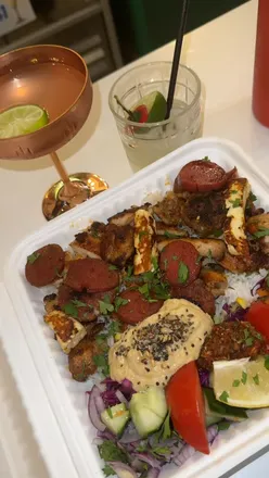 Alt text: "Mixed grill and cocktails at Booze Over Brunch, a vibrant food court in Shoreditch with diverse international cuisine.