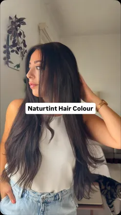 Model showcasing rich chestnut brown hair after using Naturtint's plant-based hair color and anti-ageing CC cream.
