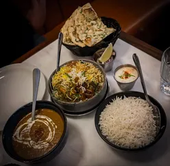 Dining experience at Indian Cafe Racer, showcasing grilled kebabs, lamb ribs, and a flavorful Chicken 65 dish.