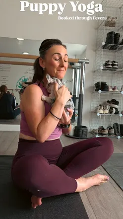 Rebecca and David enjoying puppy yoga, surrounded by adorable sleeping puppies for a joyful and unique experience.