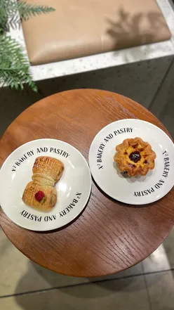 Indulging in egg tarts and croissant NATA at X2 Bakery and Pastry in London, a paradise for pastry lovers.