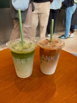 Matcha lover enjoying drinks at Blank Street café in Edinburgh, surrounded by vibrant decor and a cozy atmosphere.