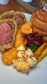 Indulging in a succulent Beef Wellington at Restaurant Roots, complete with roasted potatoes and seasonal veggies.