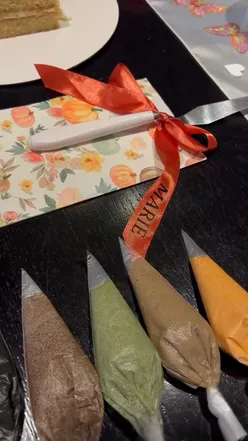 Participants enjoying a cake decorating event at Gails Bakery, surrounded by autumn vibes and creative supplies.