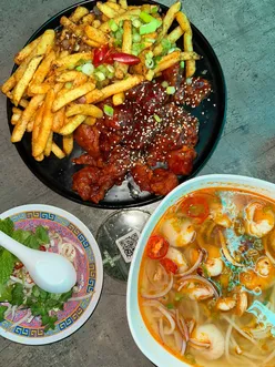 A delicious spread featuring Bun Hue Prawn, Korean Fried Chicken, and Sichuan Fries at Hello Oriental in Manchester.