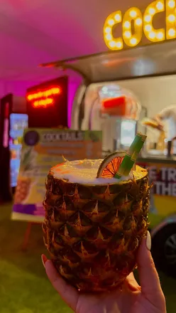People enjoying £5 cocktails at Edinburgh Cocktail Week in Festival Square, showcasing vibrant drinks and live music.