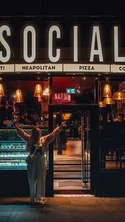 Enjoying pizzas and vibrant decor at Social by Matto in Edinburgh, featuring disco balls and stylish ambiance.