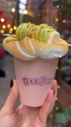 Cozy huts in Mala Secret Garden, Manchester, featuring stunning pistachio hot chocolate topped with meringue.