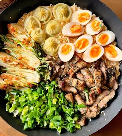 Delicious homemade noodles with creamy sauce, pork belly, dumplings, and roasted Pak Choi for a flavorful Sunday meal.