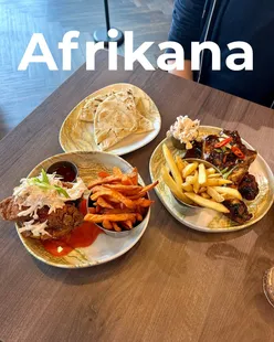 Delicious spread at Afrikana on Wilmslow Road: jerk wings, fried chicken on brioche, flatbread, and refreshing fruit punch.