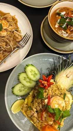 Colorful Thai dishes including Pad Thai, Pineapple Rice, and Massaman Curry at Lam Nam Restaurant, Welwyn Garden City.