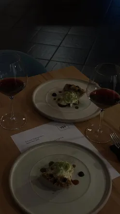 Group enjoying fine dining at a chic restaurant in Leeds, sharing laughs over wine and gourmet dishes.