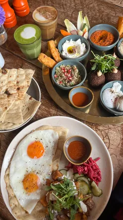 Brunch spread at queer-owned café in East London: Aya Brunch for 2, Batata Harra Hash, and seasonal pumpkin spiced latte.