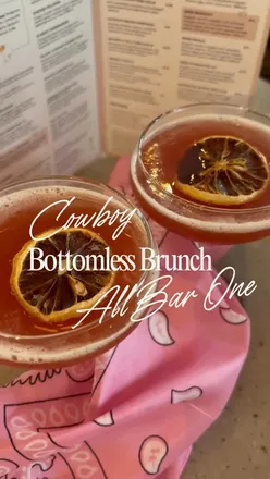 Friends enjoying Cowboy Bottomless Brunch at All Bar One, Liverpool, with drinks and brunch dishes in cowboy hats.