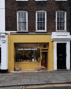 Group enjoying Lebanese breakfast dishes at Tamini Bakery in Kensington, featuring shakshuka and manakish with za'atar.