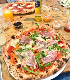 Enjoying a Romagnola pizza at Rudy's in Ancoats, Manchester, featuring prosciutto and fresh ingredients.