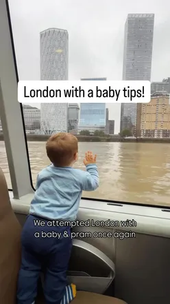 Parent exploring London with a baby in a pram, enjoying vibrant parks and attractions near Buckingham Palace.