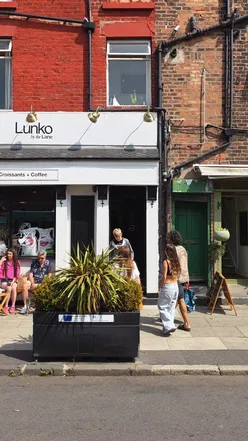 Couple enjoying a stroll on vibrant Lark Lane on a lively Friday afternoon.