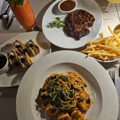 Celebrating with a feast: steak sando, prawn aglio olio, ribeye, chocolate fondant, and teh tarik in London.