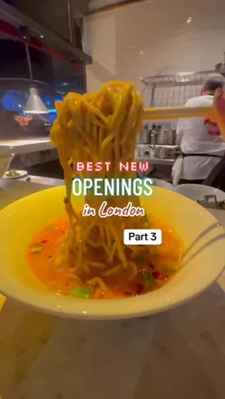 Supa Ya's British-inspired ramen served hot, featuring vibrant colors and toppings, in a cozy London setting.