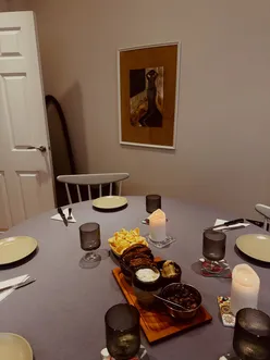 Friends enjoying an Italian Sunday lunch with risotto, cheese, olives, and festive desserts at a cozy gathering.