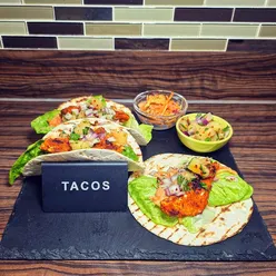 Delicious blackened fish tacos with charred shells, slaw, lettuce, and pineapple salsa for Taco Tuesday feast.