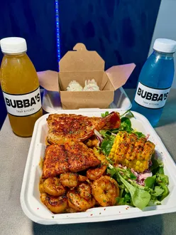 Delicious Bubba's Box featuring lobster tail, prawns, salmon, corn, mac & cheese, and decadent brownie bites.