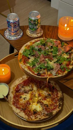 Cozy date night with pizza and Franciscan Well beers at home, perfect for a relaxing evening in.