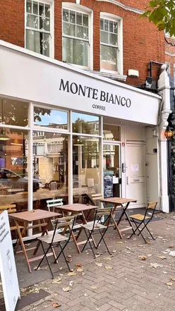 Cozy coffee break at Monte Bianco in Surbiton; enjoying smooth coffee and moist banana bread in a minimalist setting.