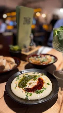 Delicious Mediterranean dishes at Zhug in Wollaton, Nottingham, featuring vibrant hummus, pita, and grilled meats.