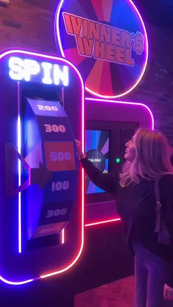 Friends preparing for a fun gameshow experience at Gameshow All Stars in Leeds, enjoying cocktails and interactive games.