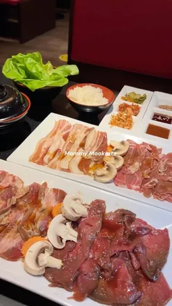 Korean BBQ setup at Mommy Mookrata in Leeds, featuring bulgogi, rice, kimchi, and fresh ingredients for an interactive meal.