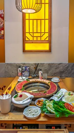 Hot pot dining at Da Long Yi in London, featuring colorful decor and a variety of fresh ingredients for an interactive meal.