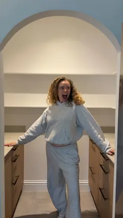 Excited influencer showcasing a newly organized pantry filled with essentials from Amazon Fresh's byAmazon range.