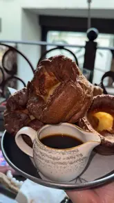 Patrons enjoying Sunday roast with Yorkshire pudding and drinks at The Botanist in Chester, reminiscing about 2025 visit.