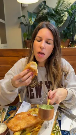 Half-price fish and chips platter at The Mayfair Chippy in Knightsbridge featuring fried hake, chips, and sauces.